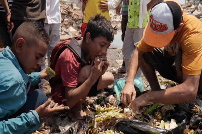 Beberapa tangan kecil menggali ke dalam kantong sampah dan memasukkan isinya ke mulut mereka. Satu potongan tampak seperti sepotong roti yang basah. (Foto: Sky News)