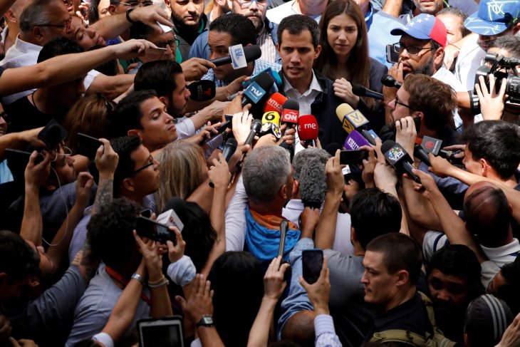 Pemimpin oposisi yang menyatakan diri sebagai presiden sementara, Juan Guaido, didampingi istrinya Fabiana Rosales berbicara kepada media setelah menghadiri misa suci di sebuah gereja di Caracas, Venezuela, 27 Januari 2019. (REUTERS/Carlos Barria)