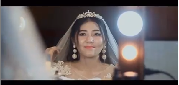 Bismillah H-3. Tulisan itu yang menyertai video Via pakai gaun pengantin.