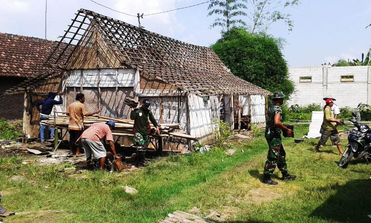 Anggota TNI Koramil 21/Sukosewu bersama masyarakat, gotong royong bongkar rumah Mbah Midjan