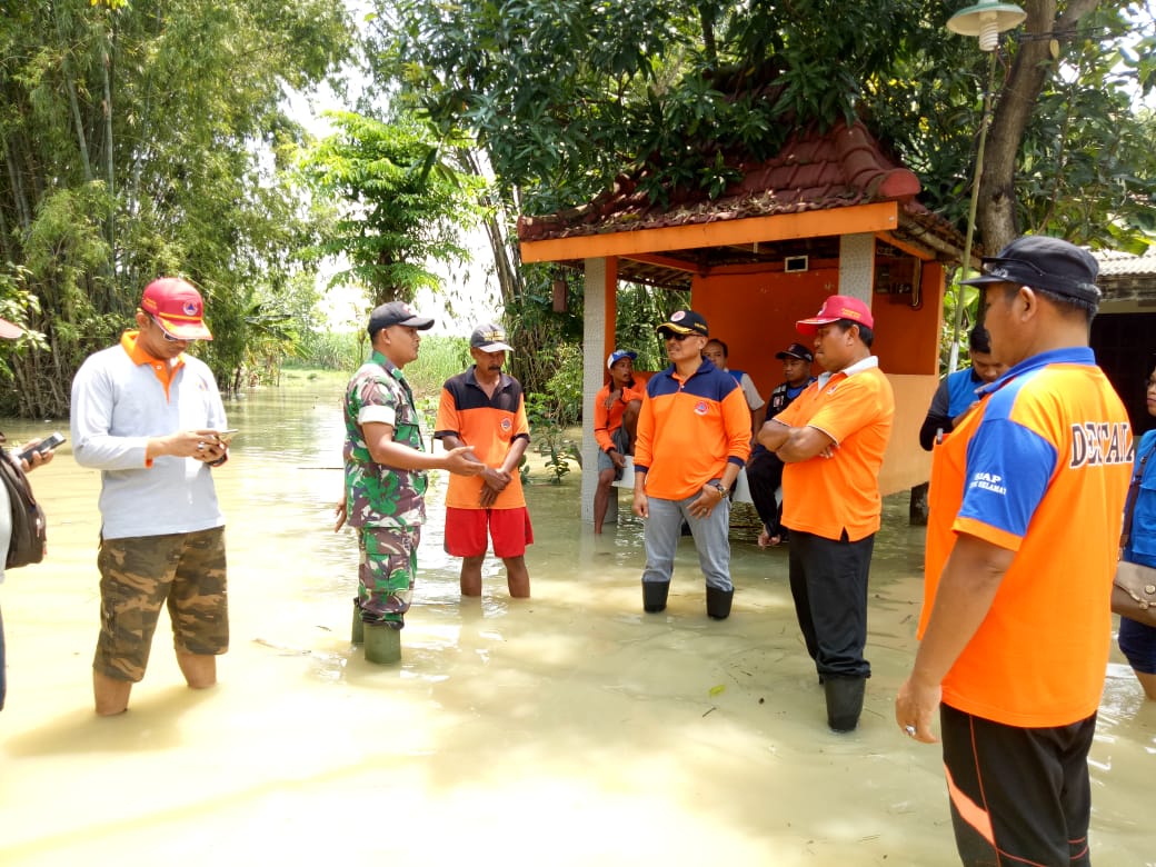 Babinsa Koramil 0815/08 Dawarblandong Kopda Jouns Yusuf Efendi saat di lokasi banjir 