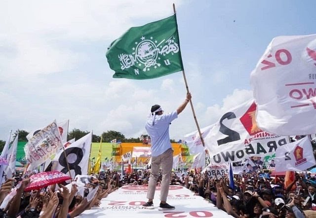 Cawapres Sandiaga Uno mengibarkan bendera NU saat kampanye di Lumajang. (Foto: istimewa)