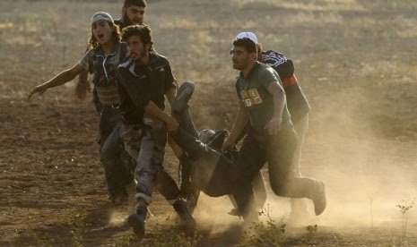 Pasukan Pembebasan Suriah (FSA) menggotong rekannya yang mengalami cedera dalam pertempuran melawan tentara Suriah loyalis Presiden Bashar Al Assad. (Foto: Antara/Reuters)