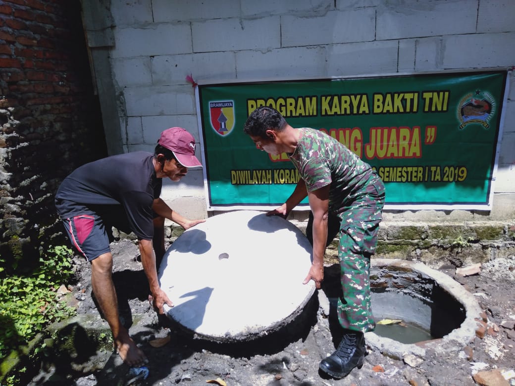 Babinsa Koramil 0815/05 Gedeg bersama warga saat membuat jamban 