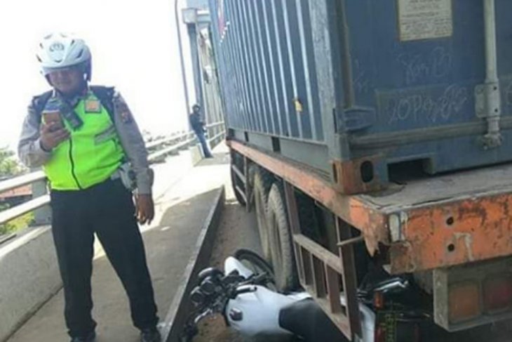 Kepala Unit Lalu-lintas Polsek Sungai Raya, Inspektur Dua Polisi Tatang, yang merelakan motor dinasnya sebagai pengganjal satu truk tronton yang remnya blong terancam terus meluncur ke belakang, di Jembatan Kapuas II, Pontianak, Jumat. (Istimewa)