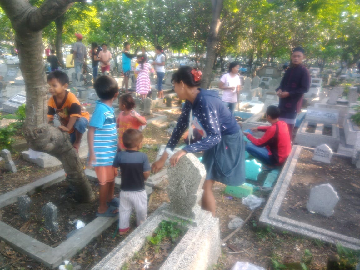 Anak berharap sedekah dari peziarah di TPU Karet Bivak, Jakarta. (Foto: asmanu/ngopibareng.id)