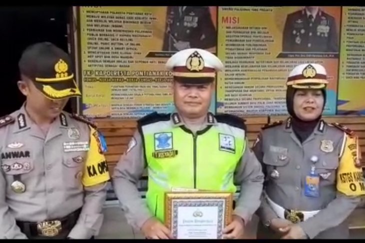 Kapolresta Pontianak, Kombes (Pol) Muhammad Anwar Nasir, Senin, memberikan penghargaan kepada Kanit Lantas Polsek Sungai Raya, Ipda Tatang yang merelakan motor dinasnya sebagai pengganjal ketika sebuah mobil tronton yang mengalami rem blong di Jembatan Kapuas 2, Jumat kemarin 3 Mei. (Istimewa)