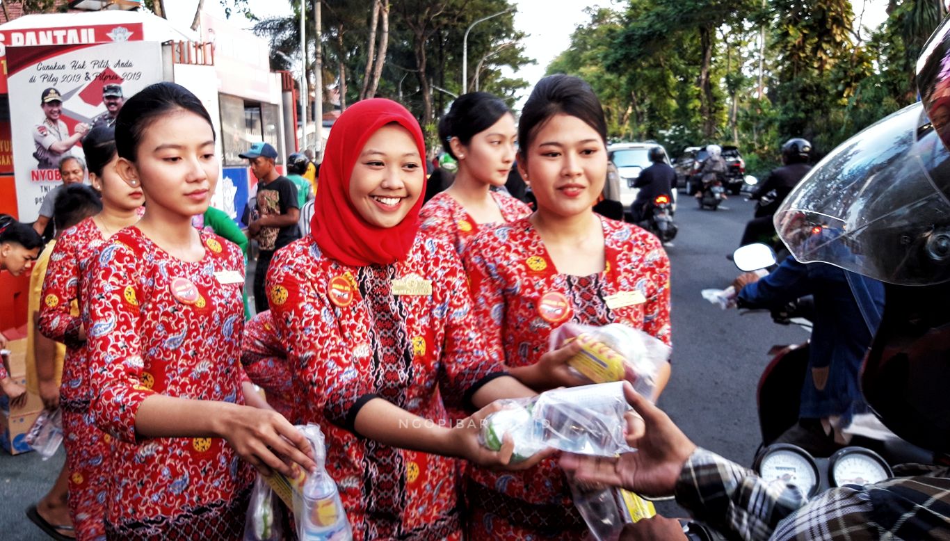 Pramugari dari sekolah Angkasa Avia berbagi takjil di depan Taman Bungkul, Surabaya. (foto: Haris/ngopibareng.id)