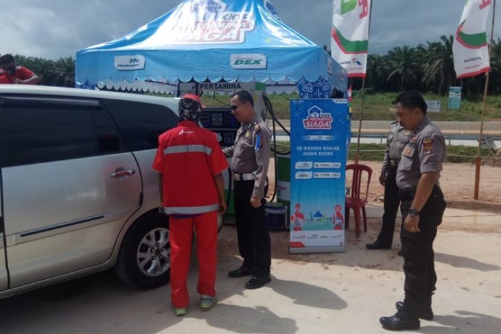 Petugas kepolisian mengecek pengisian BBM di Rest Area 234 Mesuji, Lampung, Jumat. Para pemudik mengharapkan persoalan keterbatasan stok BBM di jalan tol bisa segera diatasi oleh Pertamina. (Foto: Antara/Raharja)