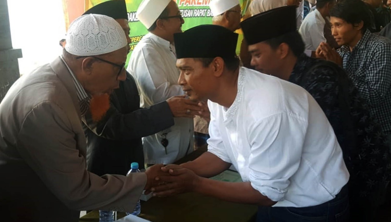 RAHMAD Hidayat (nomor dua dari kiri) menyalami sejumlah pengurus MUI usai dialog di Balai Desa Pohsangit Leres. (Foto: Ikhsan/ngopibareng.id)