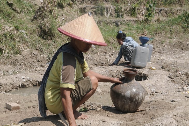 Warga mengambil air dari lubang yang digali di dasar sungai yang mengering di Dukuh Jati, Karangrayung, Grobogan, Jawa Tengah, Selasa (2/7/2019). Warga setempat kesulitan untuk mendapatkan air bersih sejak satu bulan terakhir sehingga mereka memanfaatkan sumber air dari dasar sungai untuk keperluan rumah tangga dan ternak, meski kondisi air kurang layak. (Foto: Antara/Yusuf Nugroho)