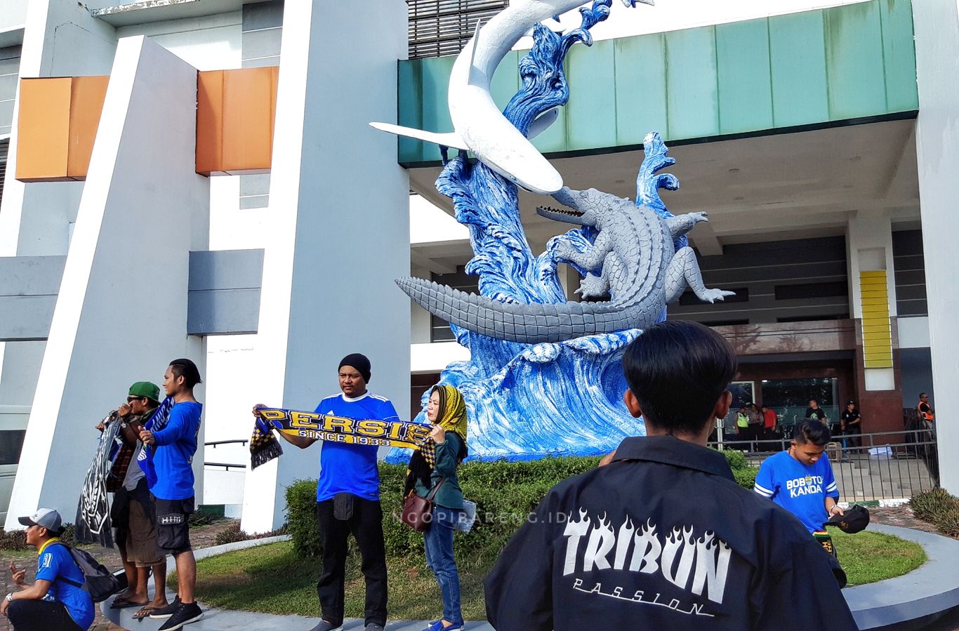 Suporter Persib berswafoto di depan patung Suroboyo, Stadion Gelora Bung Tomo. (Foto: Haris/ngopibareng.id)