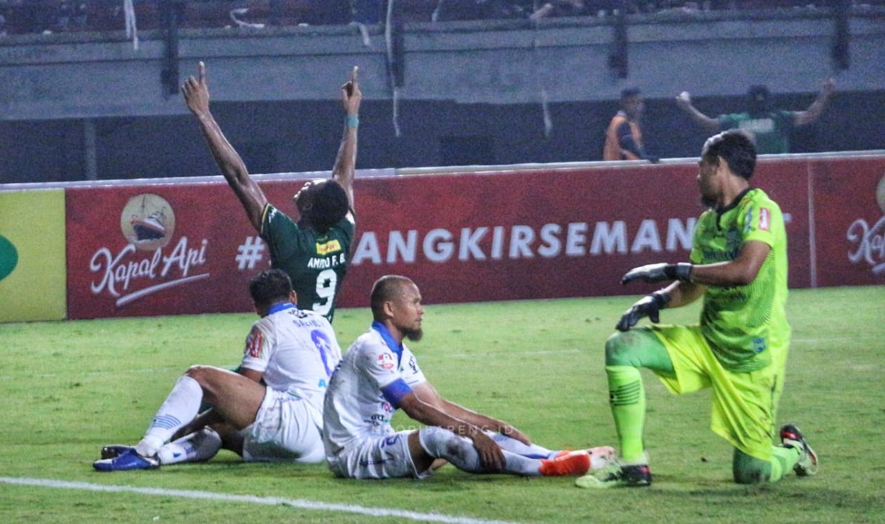 Amido Balde melakukan selebrasi di antara pemain Persib yang lemas setelah dibobol striker asing Bajul Ijo itu untuk ketiga kalinya. (Foto: Haris/@ngopibareng.id)