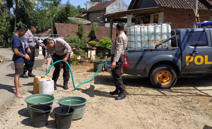 Anggota polisi ikut mendistribusikan air bersih ke warga di pacitan. (Foto:Antara)