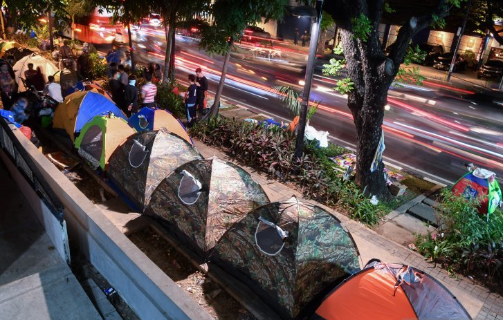  Sejumlah pencari suaka beraktivitas di dekat tenda yang didirikan di trotoar Jalan Kebon Sirih, Jakarta, Rabu (10/7/2019). Pencari suaka yang berasal dari sejumlah negara seperti Somalia, Sudan, Pakistan dan Afganistan yang saat ini masih berkemah di sepanjang trotoar tersebut akan dipindah ke Masjid Raya Jakarta Islamic Center. (Foto: Antara/Wahyu 