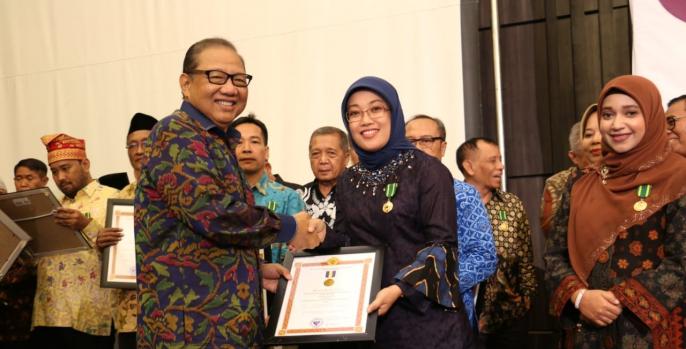 Menteri Koperasi dan Usaha Kecil dan Menengah, Anak Agung Ngurah Puspayoga memberikan penghargaan kepada Ketua Dekranasda Kabupaten Pasuruan, Lulis Irsyad Yusuf, Kamis, 11 Juli 2019 di Banyumas, Jawa Tengah. (Foto: Humas Pemkab)