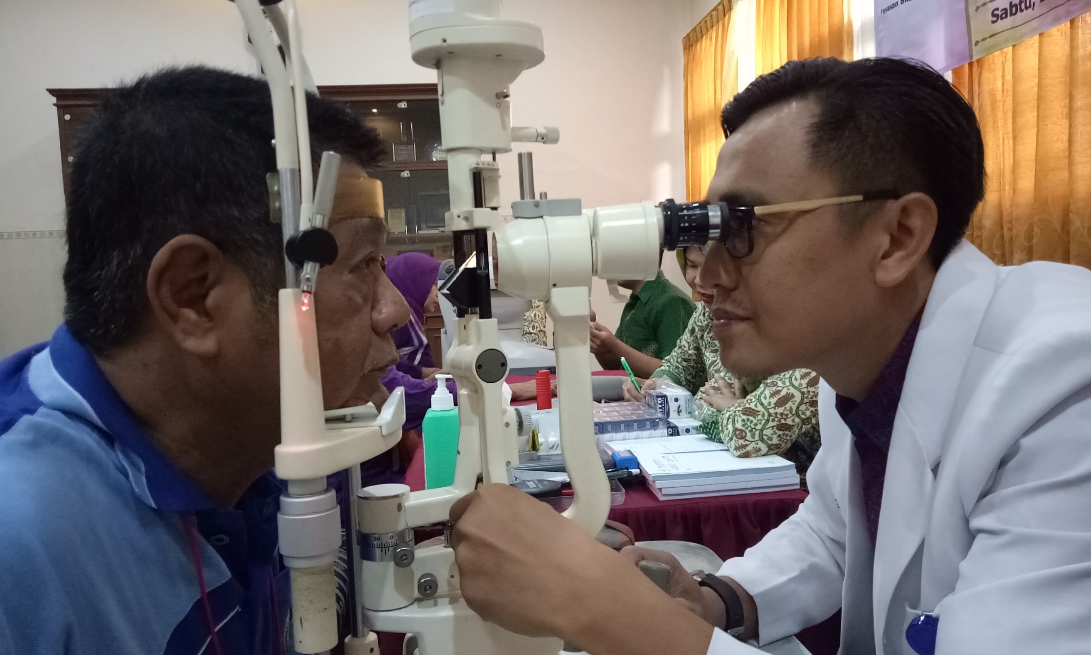 Dokter Dedik Ipung Setiyawan, Sp.M  dari RSMU melakukan pemeriksaan mata ke salah satu lansia. (Foto: Pita/ngopibareng.id)