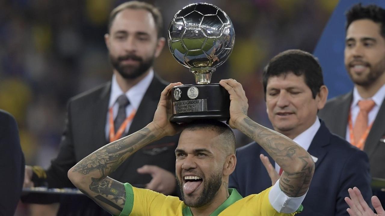 Foto: Kapten Timnas Brasil, Dani Alves, mengangkat trofi Copa America 2019 di Stadion Maracana, Rio de Janeiro, Brasil. (Foto: AFP/Carl De Souza)