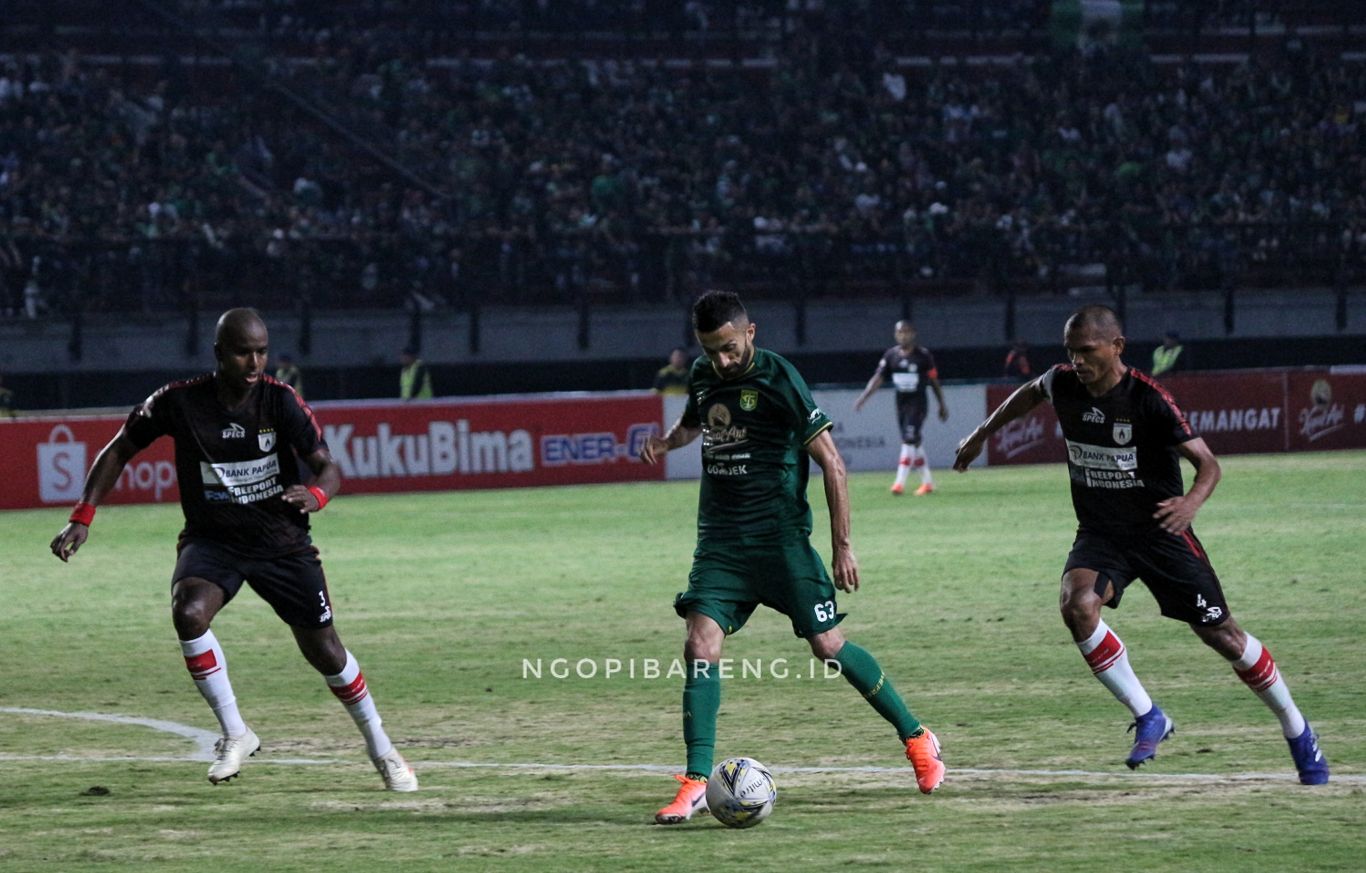 Pemain Persebaya, Manu Dzhalilov saat berusaha melewati dua pemain Persipura. (Foto: Haris/ngopibareng.id)