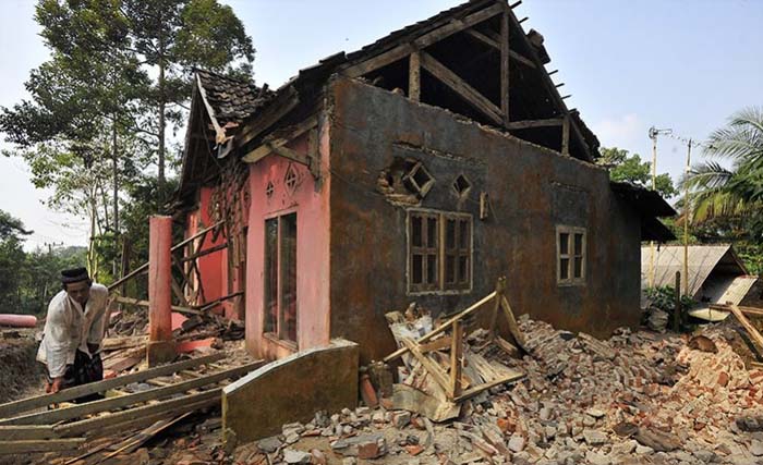 Seorang warga di Kampung Karoya, Mandalawangi, Pandeglang, hari Sabtu memunguti puing-puing yang ada di depan rumahnya yang rusak akibat gempa Jumat malam. (Foto:Antara)Banten, Sabtu (3/8/2019).