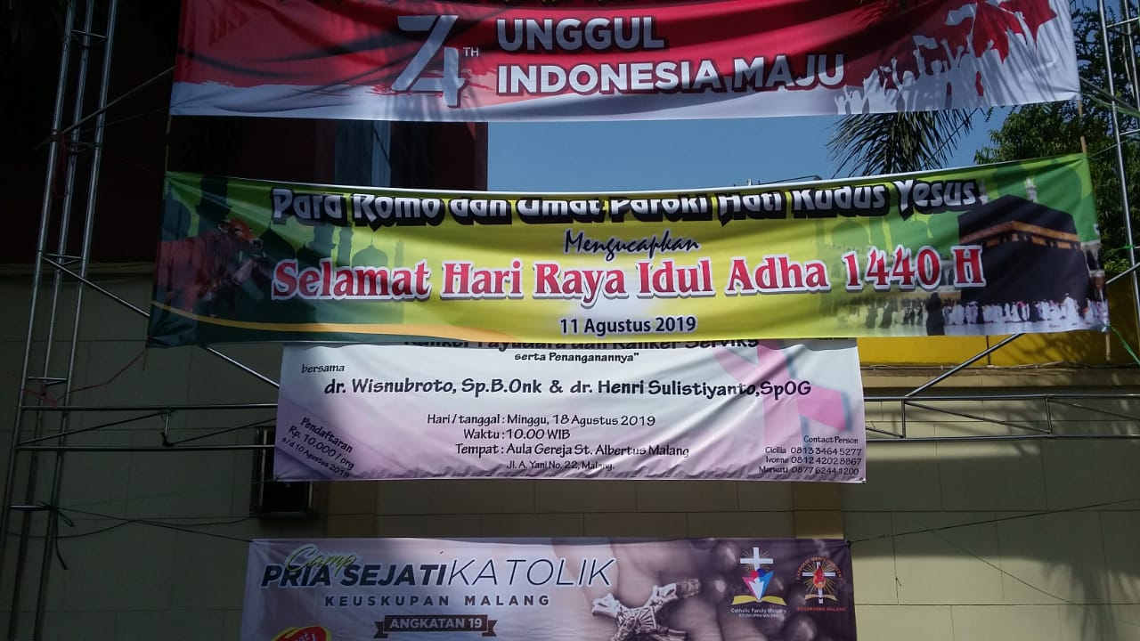 Ucapan Selamat Idul Adha 1440 H dari Romo dan Umat Paroki Gereja Katolik Hati Kudus Yesus di pelatran halaman rumah ibadah tersebut (Theo/Ngopibareng.id)