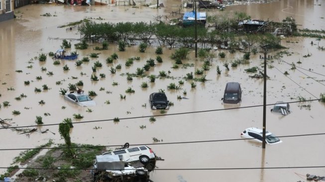 Gelombang laut menghantam jalanan depan bangunan di Taizhou, Provinsi Zhejiang di China akibat Topan Lekima pada 9 Agustus 2019. (AFP)