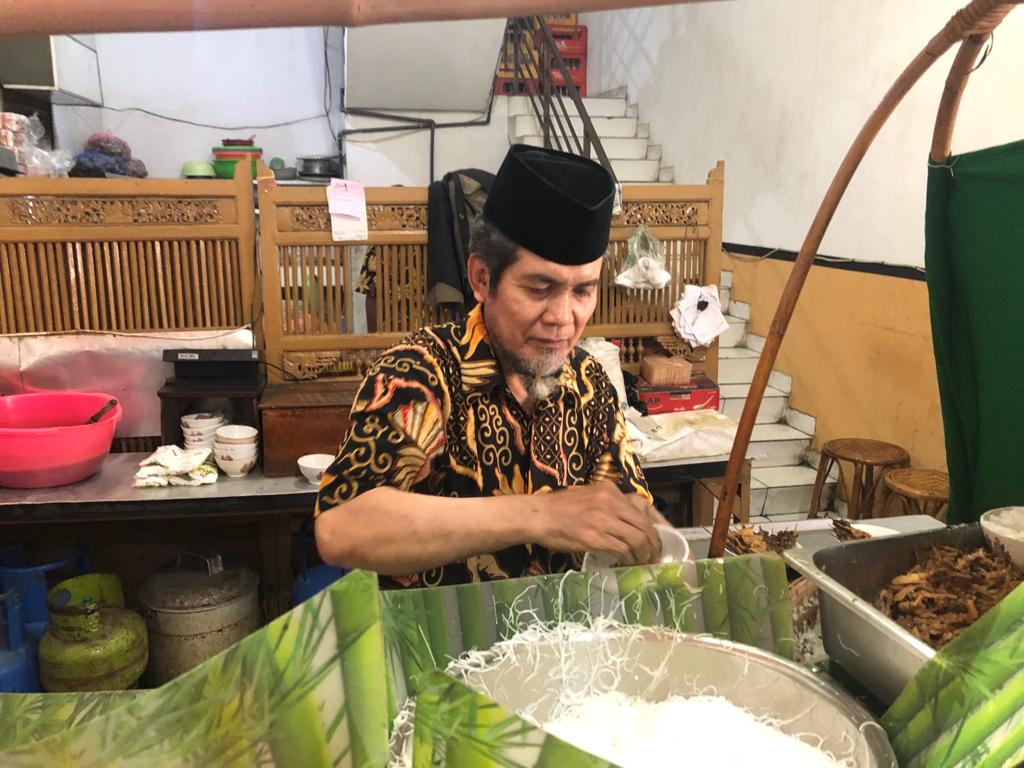 Pak Darno meracik soto ayam untuk pelanggan. (Foto arif afandi/ngopibareng.id)