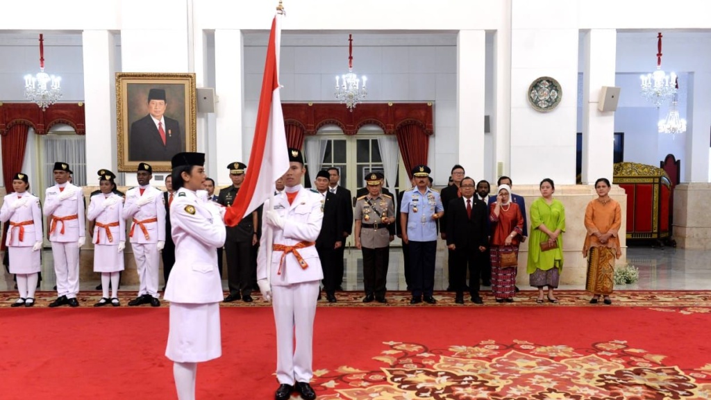 I Dewa Agung Ayu Alamanda Diastara, anggota Paskibraka 2019 dari Provinsi Bali,  mewakili rekan-rekannya untuk memegang bendera merah putih saat pengucapan ikrar Putra Indonesia.( foto: asmanu/ngopibareng.id).