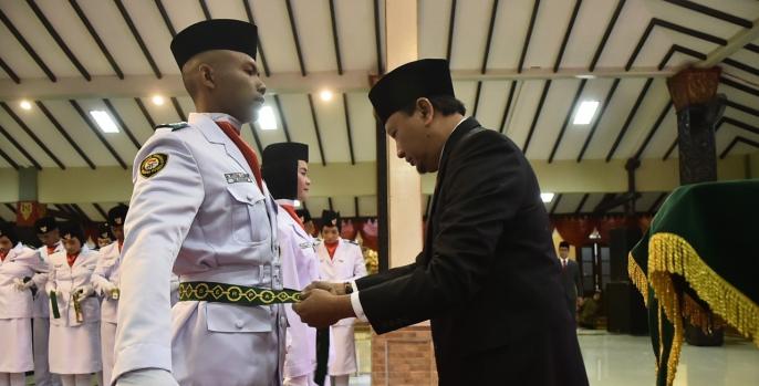 Bupati Irsyad Yusuf menyematkan tanda pengukuhan kepada 74 Paskibraka Pasuruan. Foto: Dok Humas)