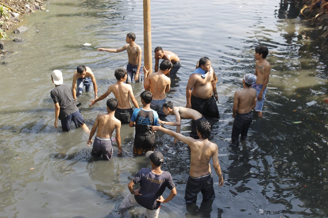 Panjat pinang simbul perjuangan untuk mendampatkan sesuatu. Persatuan dan kebersamaan menjadi penting bagi peserta panjat pinang. (foto: Asmanu/ngopibsreng.id)