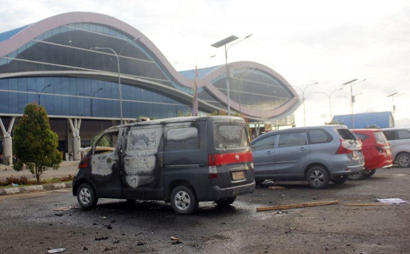 Bangkai mobil milik Polisi yang rusak di parkiran Bandara Domine Eduard Osok (DEO) Kota Sorong, Papua Barat, Senin 19 Agustus 2019. Massa yang protes karena penahanan dan penghinaan mahasiswa Papua di Surabaya, Jawa Timur itu melakukan aksi long march dengan perusakan fasilitas seperti Bandara, Kantor DPRD, pertokoan, rumah dan gerobak pedagang. (Foto: Antara/Olha Mulalinda)