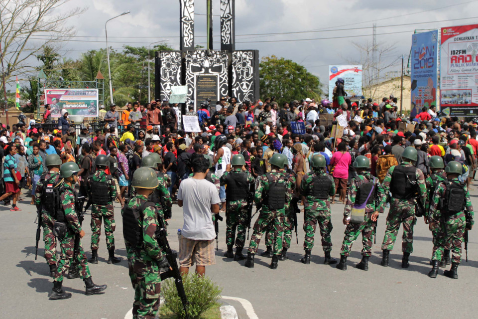 Warga melakukan aksi dengan pengawalan prajurut TNI di Bundaran Timika Indah, Mimika, Papua, Rabu, 21 Agustus 2019. (Foto: Antara)