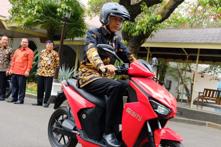 Presiden Jokowi mengendarai motor listrik.