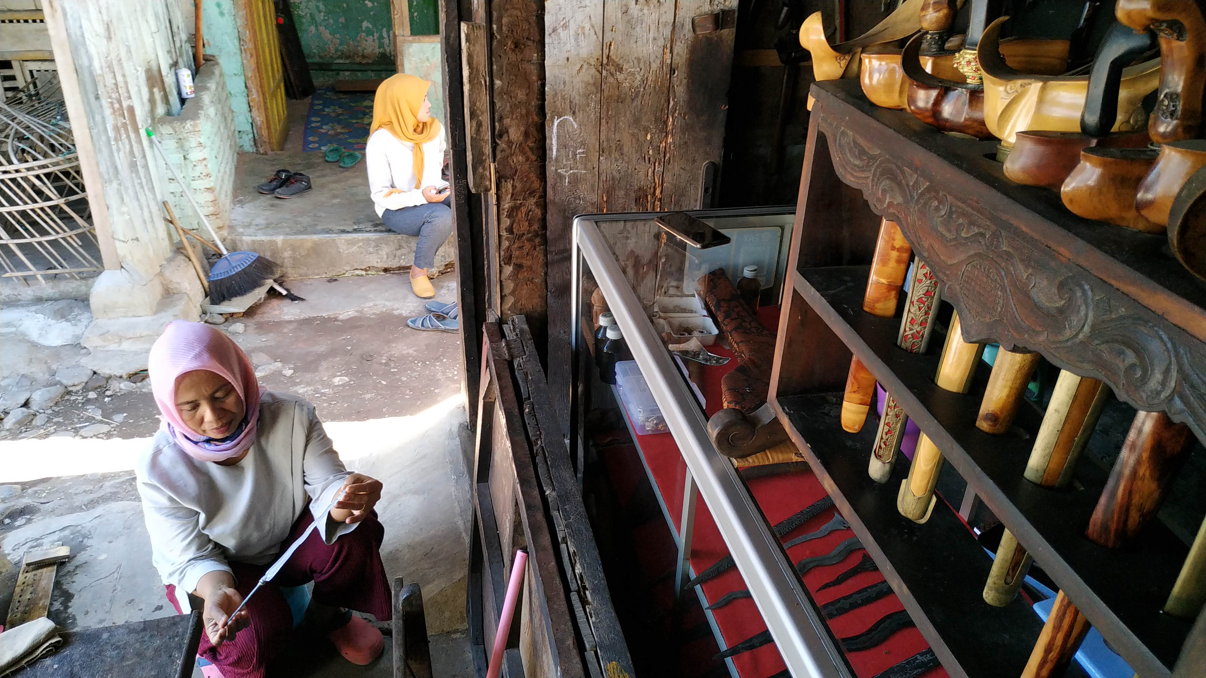 Mariyani, salah satu penyedia jasa pencucian pusaka di Pasar Setono Betek, Kota Kediri saat mencuci keris milik pelanggannya. (Foto: Fendhy Plesmana/Ngopibareng.id)