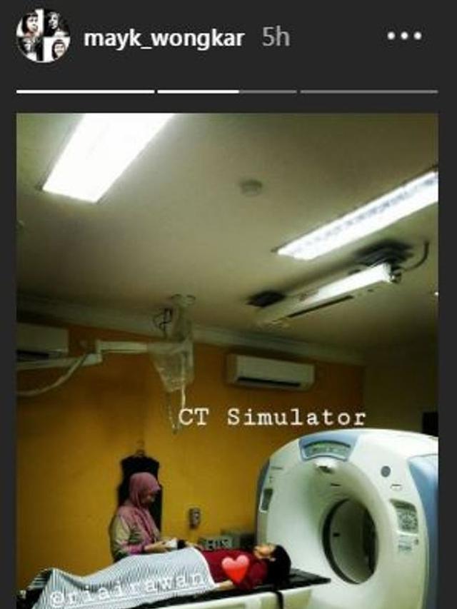 Ria Irawan yang mengenakan atasan merah, siap masuk dalam mesin CT Simulator. (Foto: Instagram Maiki Wongkar)