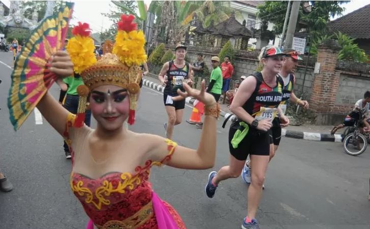 Sejumlah peserta berlari di samping penari Bali saat mengikuti Maybank Bali Marathon 2019 di kawasan Gianyar, Bali, Minggu 8 September 2019. Sebanyak 11.659 pelari dari 50 negara seperti Kenya, Australia, Amerika Serikat, Jepang dan Malaysia mengikuti Maybank Bali Marathon 2019 yang diselenggarakan dengan melintasi wilayah Kabupaten Gianyar dan Kabupaten Klungkung. (Foto: Antara/Fikri Yusuf)