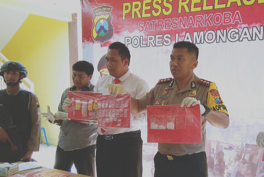 Kapolres Lamongan, AKBP Feby DP Hutagalung (kanan) saat menunjukkan barang bukti yang diamankan petugas. (Foto: Nasih/ngopibareng.id)