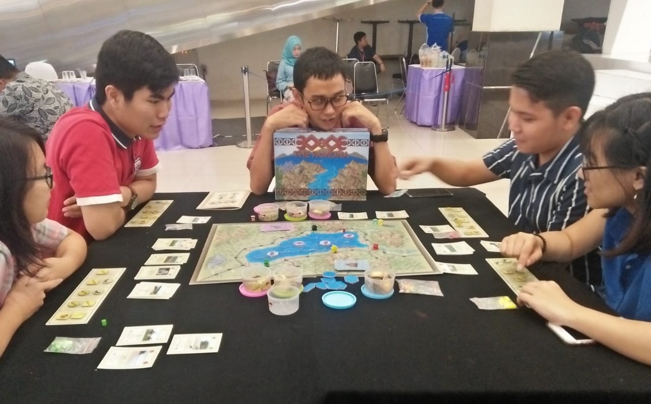 Victor Riyois Sorongku (tengah) saat mempraktekan board game 'The Pomana' yang ia buat. (Foto: Istimewa) 