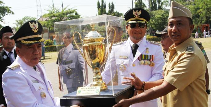 Bupati Pasuruan Irsyad Yusuf didampingi Wakil Bupati KH Mujib Imron membawa piala WTN usai melaksanakan upacara hari jadi ke-1090. (Foto: Dok Humas)