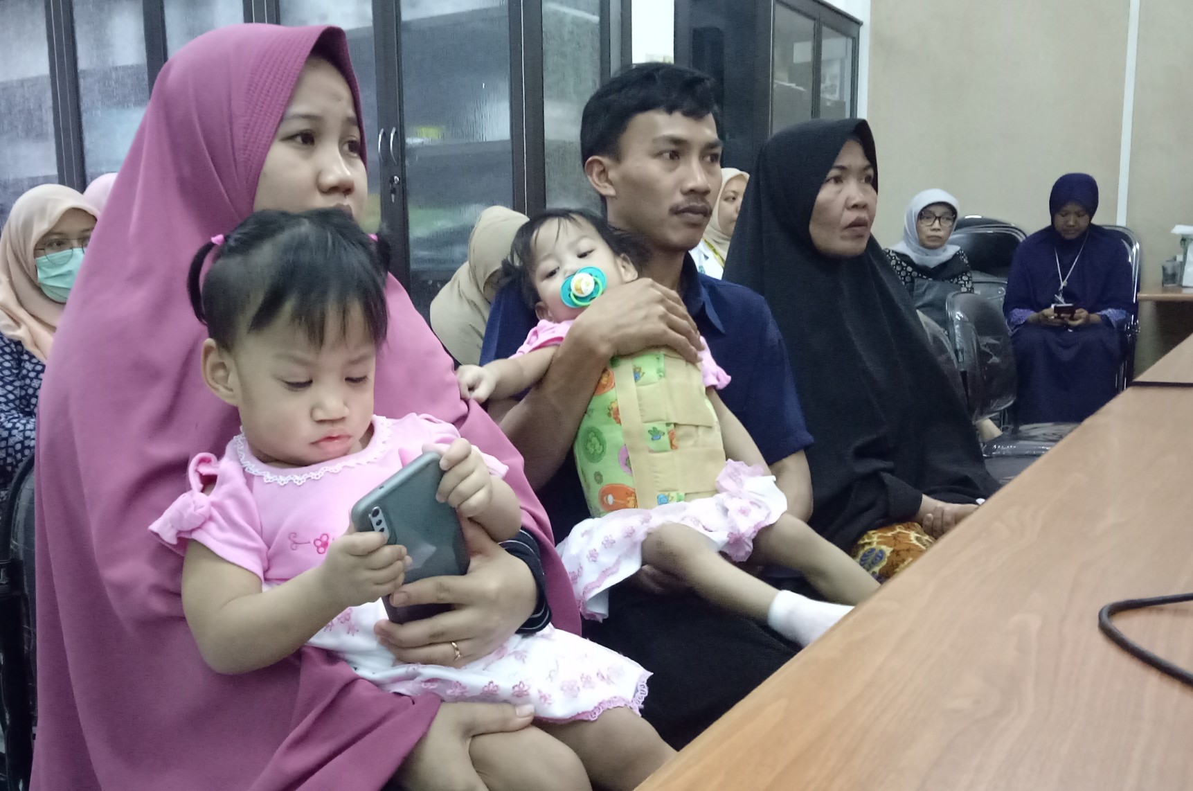 Salah satu bayi kembar siam yang berhasil dipisahkan Akila berada di gendongan sang ibu, Selviana Dewi. Sedangkan Azila berada di pangkuan ayahnya, Yayasrin. Tim Pusat Pelayanan Kembar Siam Terpadu RSUD Dr. Soetomo Surabaya siang tadi mengadakan acara syukuran atas keberhasilan memisahkan bayi kembar siam Azila Dewi Sabrina dan Akila Dewi Syabila asal Kendari, Jum'at, 20 September 2019. (Foto: Pita/ngopibareng.id)