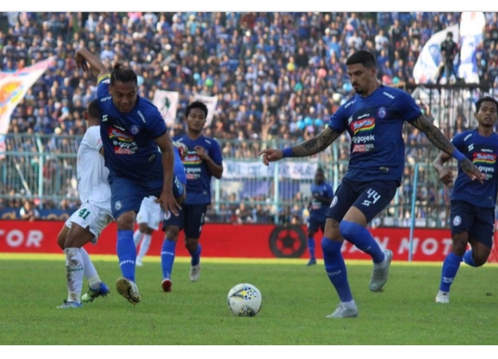 Kapten Tim Arema FC, Hamka Hamzah (kiri) bersama duet lini belakangnya Arthur Cunha da Rocha saat mengamankan lini pertahanan Singo Edan. (Foto: Haris/ngopibareng.id)