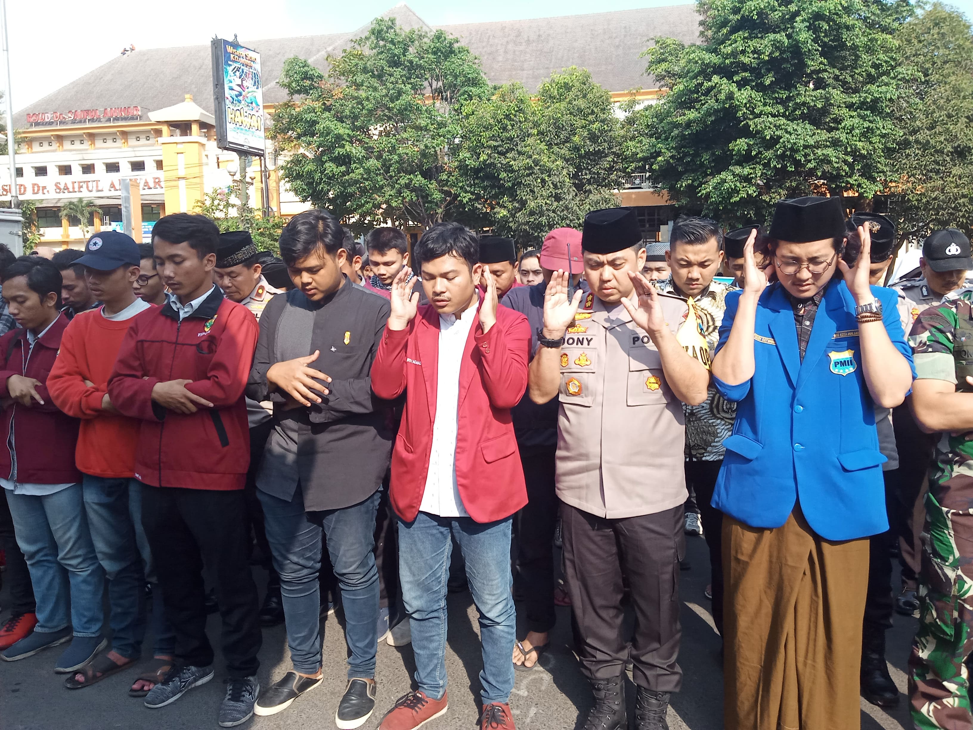 Salat gaib yang dilakukan IMM dan PMII Malang di depan Mapolresta Malang. Selain itu salat ghaib juga diikuti anggota Polri dan TNI. (Foto: Theo/ngopibareng.id)