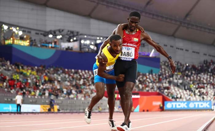 Braima Dabo dari Guinea-Bissau (kaos merah)aat membantu Johnathan Busby dari Aruba  hingga mencapai garis finish, pada Kejuaraan Dunia Atletik di Doha, Qatar, hari Jumat kemarin. (Foto:Eurosport)