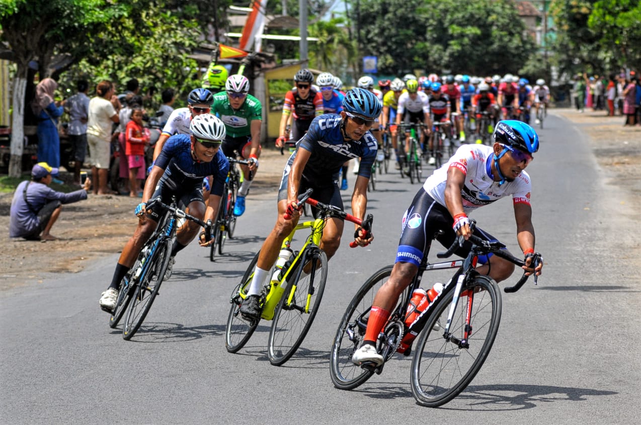 Rombongan pembalap melewati tikungan di pertigaan Benculuk, Kecamatan Celuring, Kabupaten Banyuwangi. Sabtu, 28 September 2019. (Foto: Erfan/ngopibareng.id)