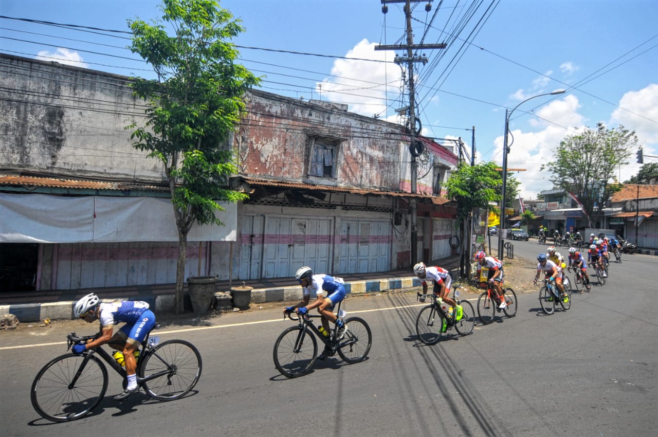 Rombongan pembalap melewati tikungan di pertigaan Srono, Kecamatan Srono, Kabupaten Banyuwangi. (Foto: Erfan/ngopibareng.id)