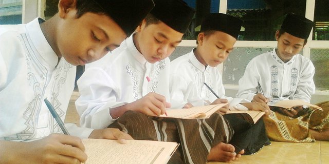 Para santri sedang melakukan pencatatan dalam Kitab Kuning. (Foto: dok/ngopibareng.id)