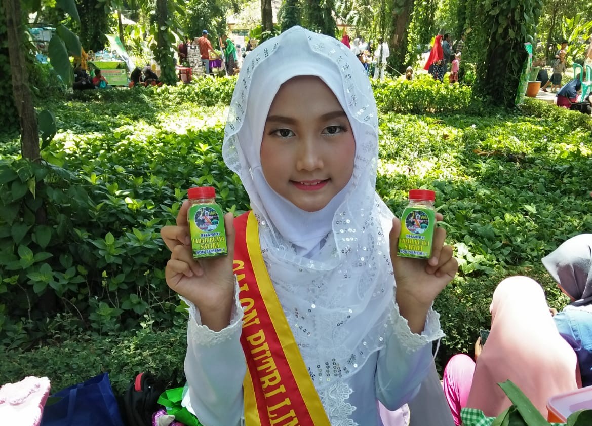 Safira, siswa kelas 6 SDN Sememi 1 menunjukan hasil inovasi sampo lidah buayanya.  (Foto: istimewa) )