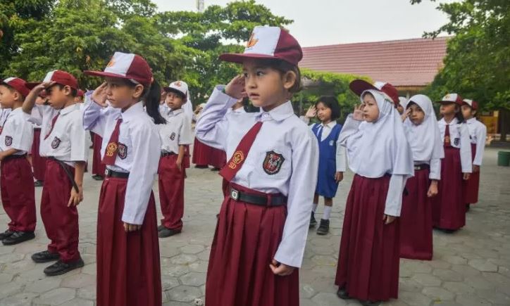 Seorang anak pencari suaka (tengah) yang kini duduk di kelas 1 SDN 159 hormat saat mengikuti upacara bendera di Kota Pekanbaru, Riau, Senin (7/10/2019). (Foto: Antara/FB Anggoro)