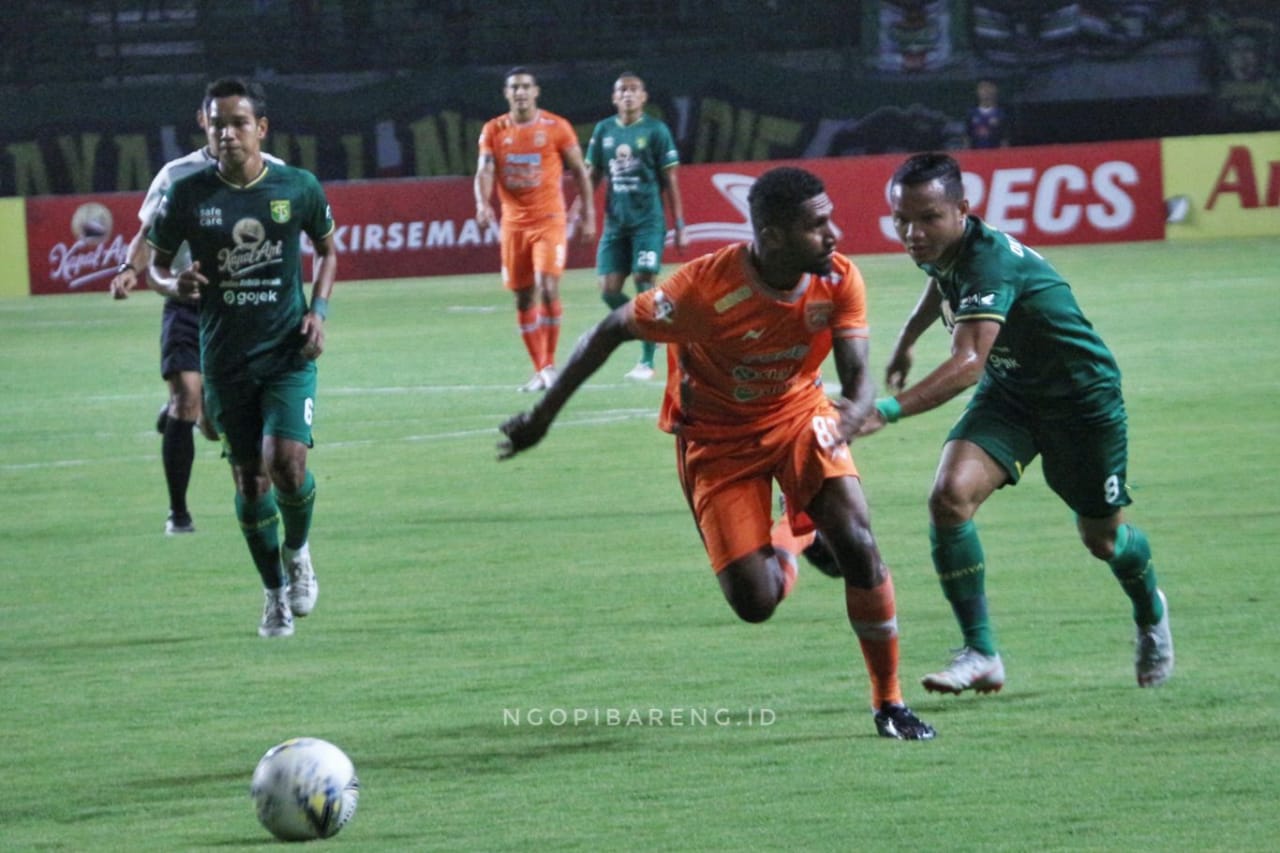 Pemain Persebaya Oktafianus Fernando (hijau) saat berebut bola sengan pemain Borneo FC Makarius Fedrik (orange), di Stadion Gelora Bung Tomo, Jumat 11 Oktober 2019. (Foto: Haris/ngopibareng.id)