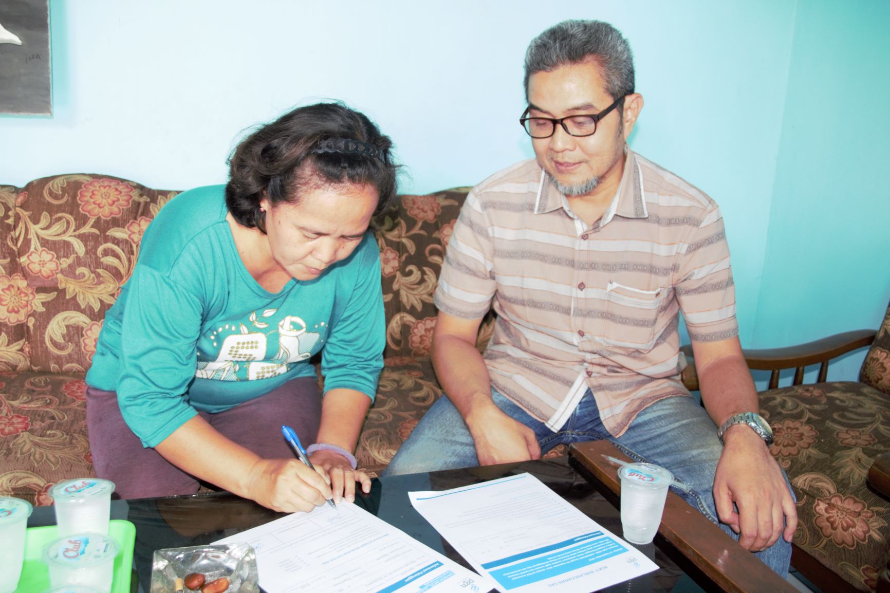 Sales Representative PGN Wilayah Mojokerto, Supriyono saat melakukan penandatanganan berita acara gas in dengan salah satu pelanggan di Prajurit Kulon, Kota Mojokerto. (Foto: Rizal/ngopibareng.id)